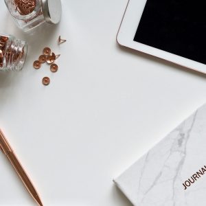 Journal spirituel papier ou digital : carnet marbré, stylo, tablette et accessoires de papeterie sur fond blanc